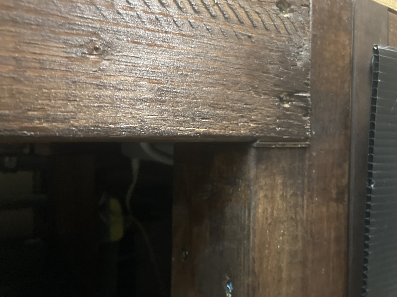 水槽台の水平調整のため薄板を挟んで隙間を調整している様子