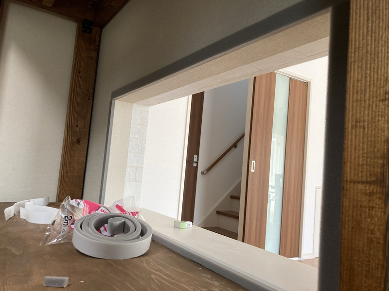 水槽と壁の隙間に隙間テープを貼り、防音・断熱処理を行っている様子