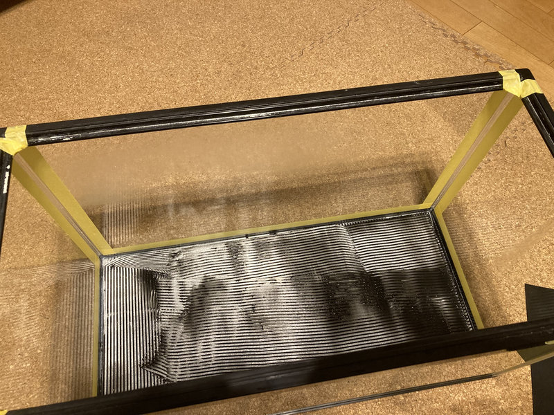 水槽の底面にシリコンを塗る様子