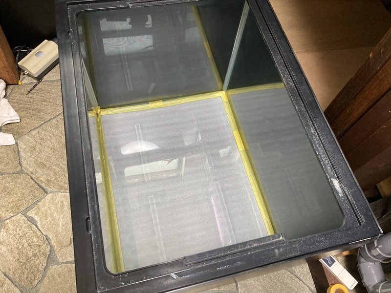 水槽にもともと施工されているシリコンにブラックシリコンが付着しない様、マスキングテープで養生している様子